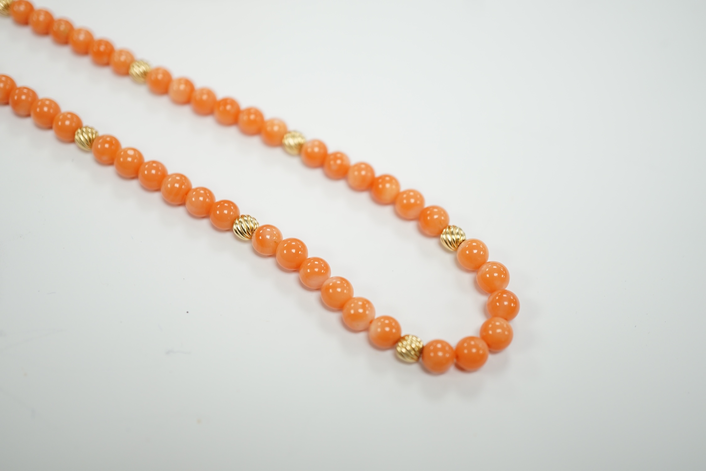 A modern 14k mounted twin strand coral bead necklace, 17cm, together with a 14k mounted single strand coral bead necklace, 44cm.